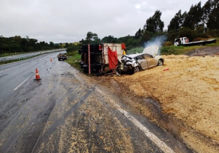 Mulher morre após carro derrapar e bater em caminhão tombado.