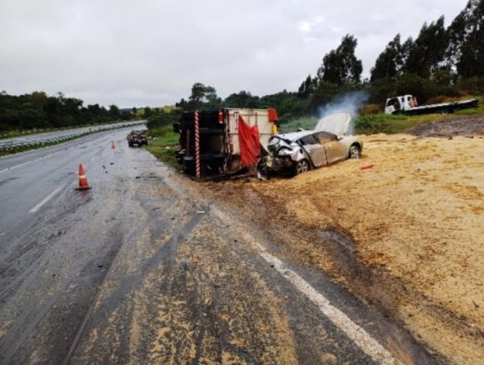 Mulher morre após carro derrapar e bater em caminhão tombado.